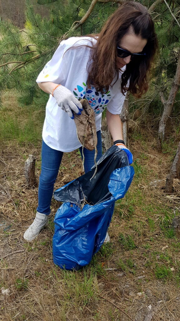 kobieta zbiera śmieci - Operacja „Czysta Rzeka”