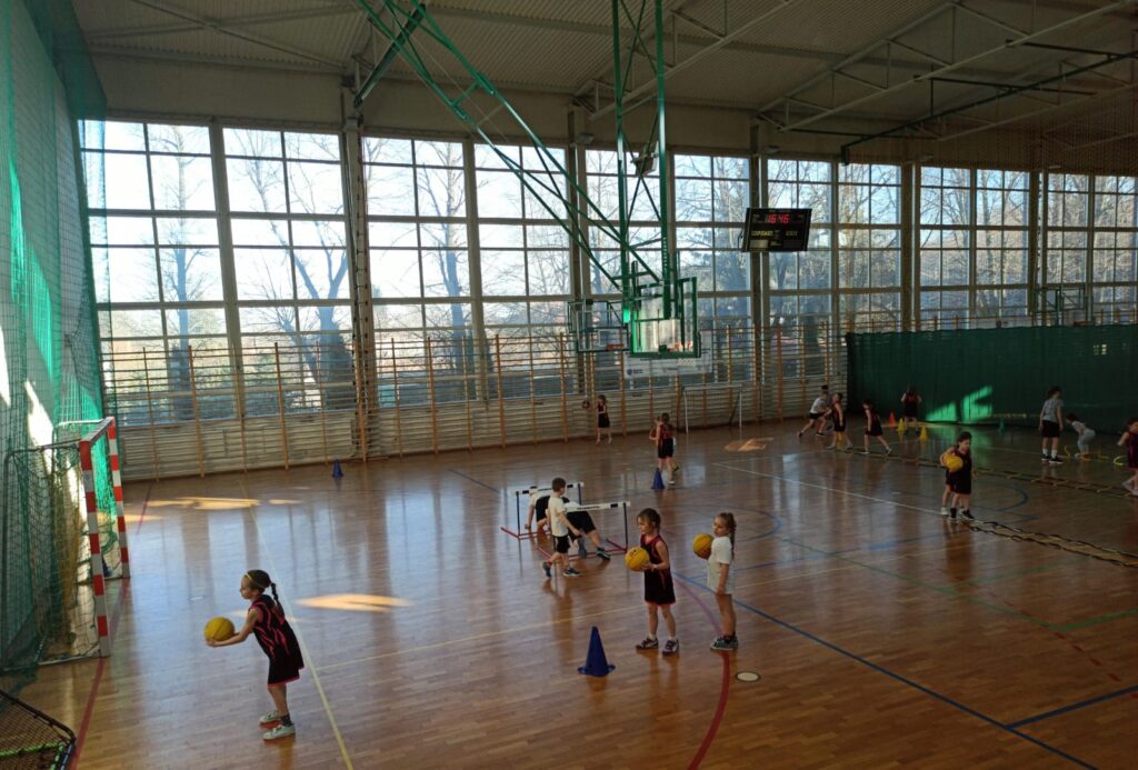 Młode koszykarki w sali gimnastycznej