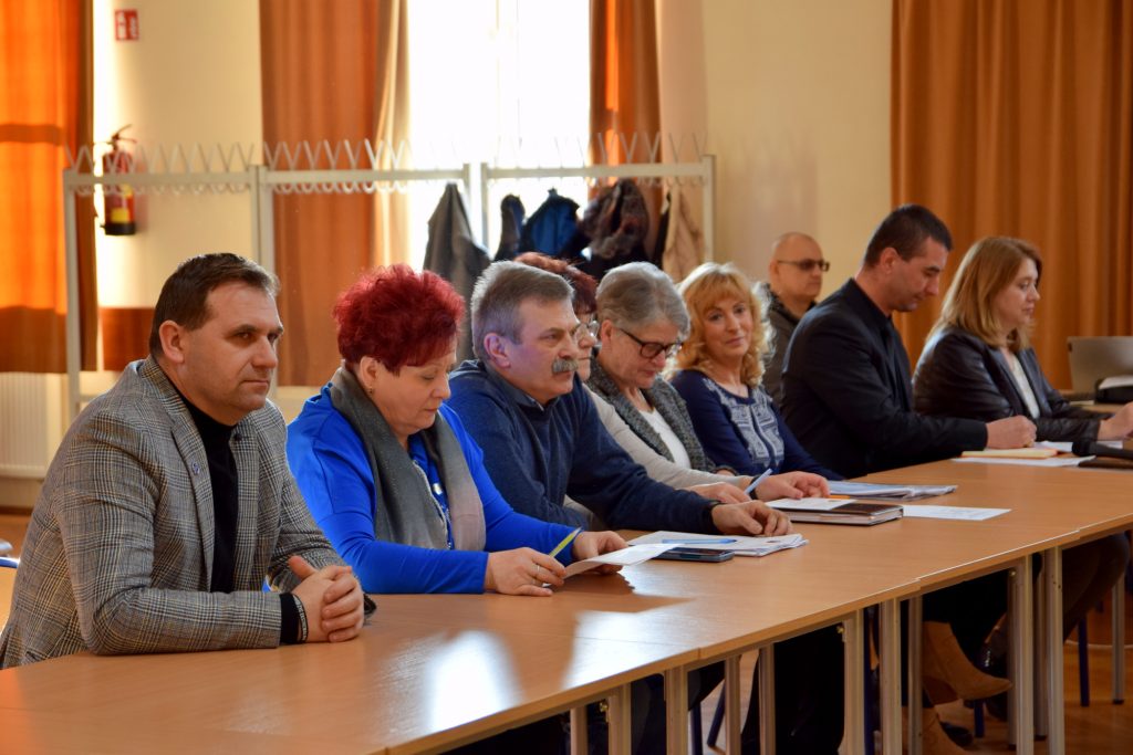 Plany rozbudowy i modernizacji drogi w Marcinkowie - 7 osób siedzi przy stole na obradach sesji Rady Miejskiej 