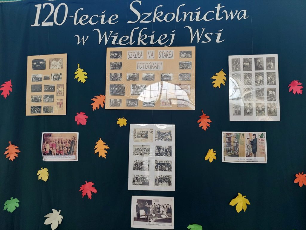 Ekspozycja ścienna upamiętniająca 120 lat oświaty w Wielkiej Wsi. Znajdują się na niej historyczne zdjęcia i kolorowe jesienne liście.