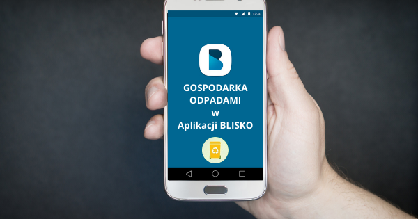 Ręka trzyma smartfon z włączoną aplikacją „BLISKO”, na niebieskim tle widnieje napis „Gospodarka Odpadami”.