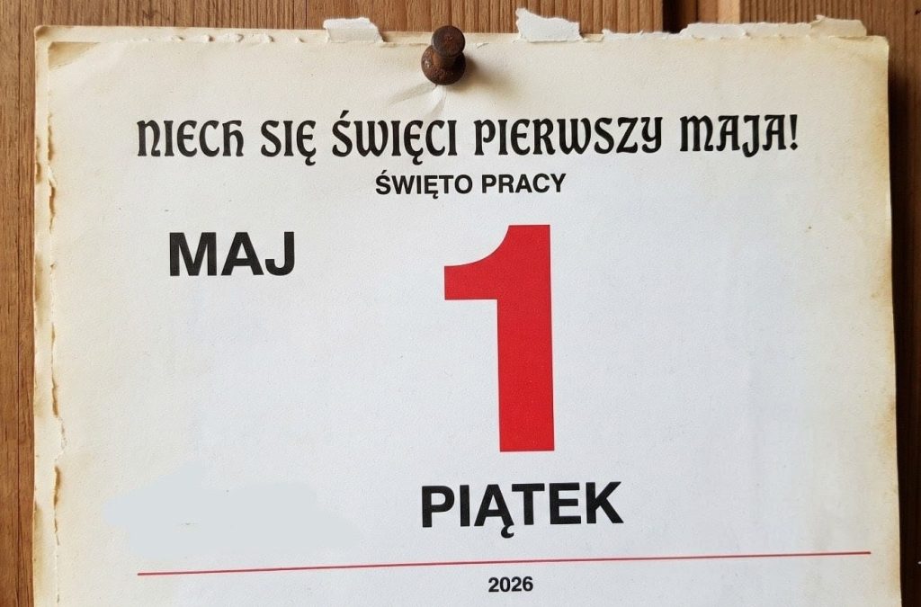 Ten obraz przedstawia pojedynczą, vintage’ową kartkę z kalendarza, przypiętą rdzawą pinezką na tło z naturalnego drewna. Kartka ma postrzępione i pożółkłe krawędzie, co nadaje jej autentyczny, stary wygląd.W górnej części kartki widnieje czarny, stylizowany napis: „NIECH SIĘ ŚWIĘCI PIERWSZY MAJA!”, a bezpośrednio pod nim mniejszymi, prostymi literami: „ŚWIĘTO PRACY”.Głównym elementem centralnym jest duża, jaskrawoczerwona cyfra „1”. Nad nią, po lewej stronie, napisano czarnymi literami „MAJ”, a poniżej cyfry, dużymi, prostymi literami: „PIĄTEK”.